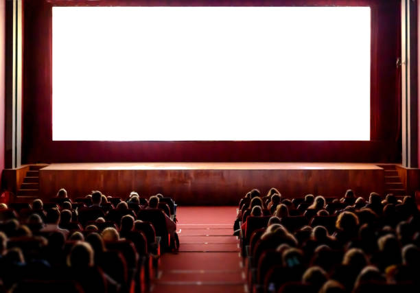 Cinema empty screen with audience. Blurred People silhouettes watching movie performance. Copy space.